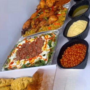 Jollof rice with grilled chicken or turkey meat, turmeric fried rice with chicken drumsticks or chicken wings, assorted salad, served with bake beans, Salad cream, mayonnaise free range, ketchup, chicken pie, and yam balls.